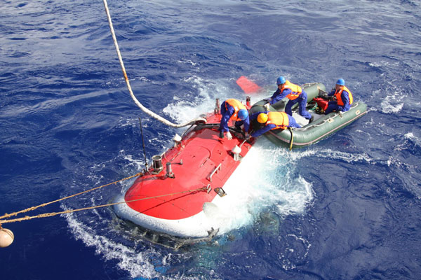 China's manned deep-sea submersible, Jiaolong, is unloaded from its oceanographic mother ship to the sea before making its first in the Mariana Trench, as part of a bid to go down as deep as 7,000 meters, June 15, 2012. Jiaolong to rise from over-6,000m-deep sea