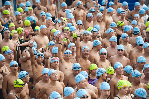 Participants wave as they prepare for the Cross Habour Race event in Hong Kong's Victoria Harbour, Oct 21, 2012. Thousands brave Hong Kong harbour swim