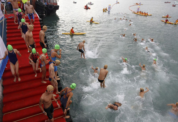 Swimmers dive into the water as they participate in the Cross Harbour Race event in Hong Kong's Victoria Harbour Oct 21, 2012. Thousands brave Hong Kong harbour swim