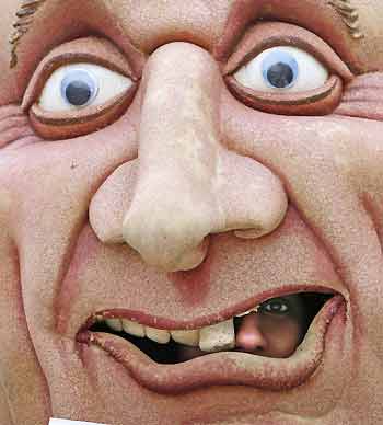 A protestor looks out from the mouth of giant effigy of Canadian Prime Minister Paul Martin during a demonstration in Kelowna, British Columbia November 24, 2005. About 50 Correctional Officers on strike protested outside the site where Martin and the provincial premiers were meeting with native leaders on Thursday.